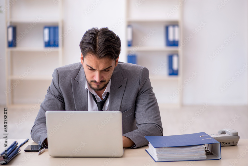 Young male employee working in the office Young male employee working in the office