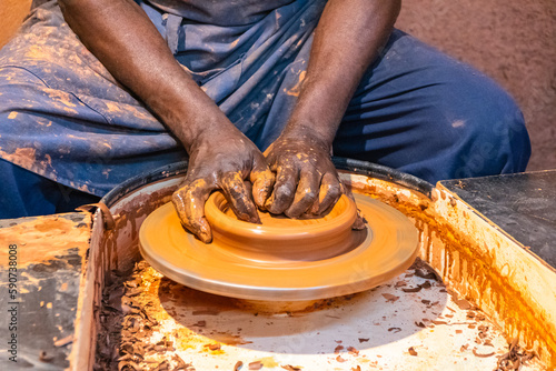 Gros plan sur les mains d'un homme qui fabrique une poterie en argile. 