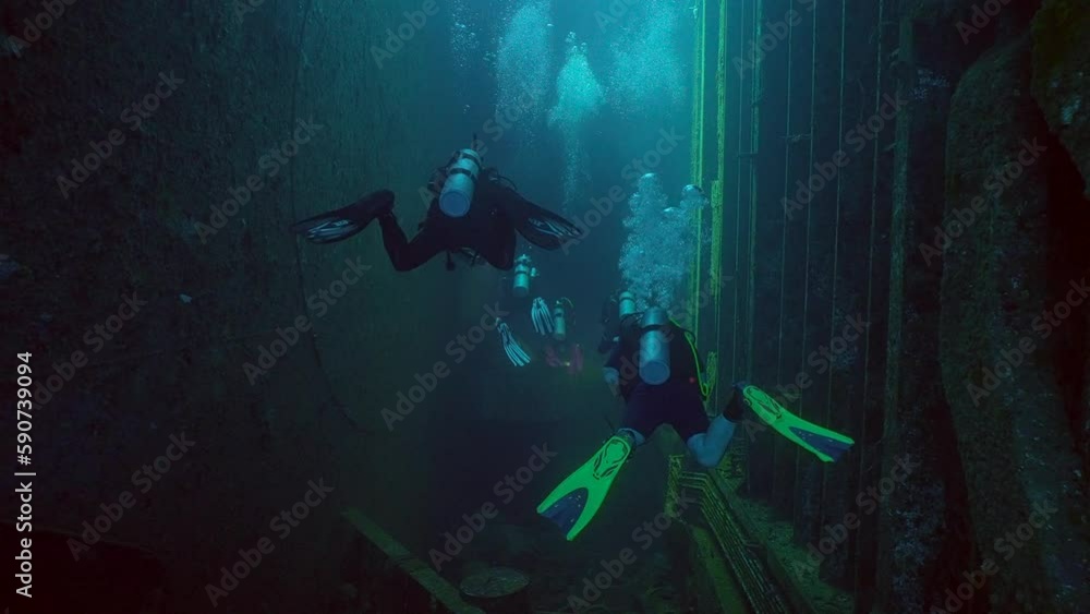 Scuba divers swimming inside hold of ferry Salem Express shipwreck, Slow motion Scuba divers swimming inside hold of ferry Salem Express shipwreck, Slow motion