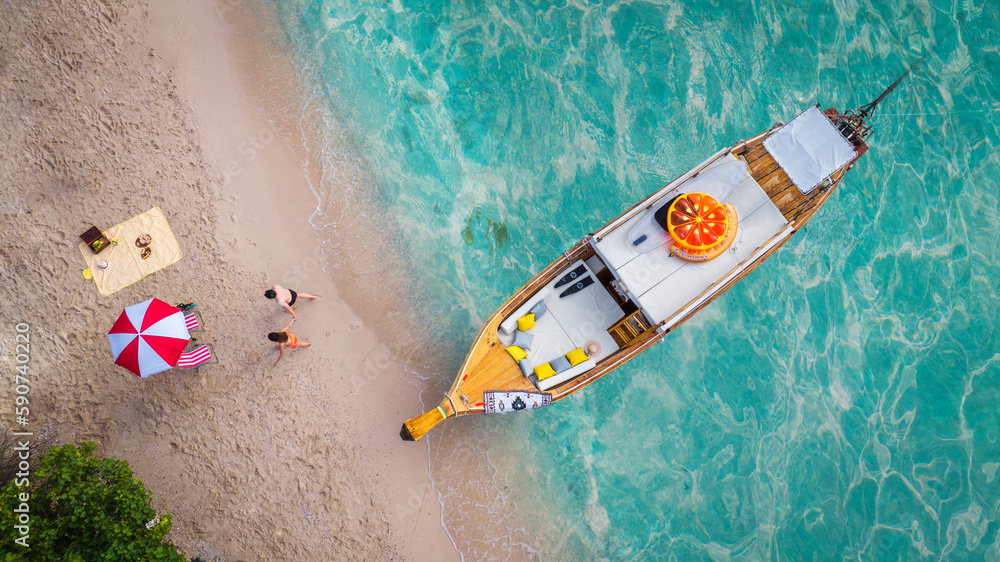 Top view of travel boat, traveller couple, beach and blue sea in summer time