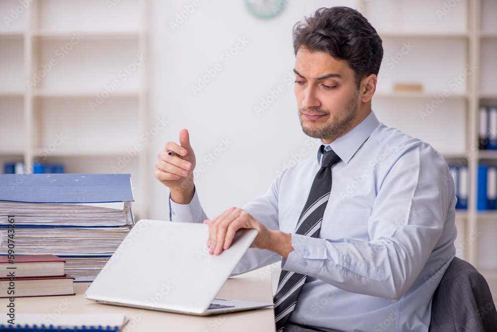 Young male employee working in the office Young male employee working in the office