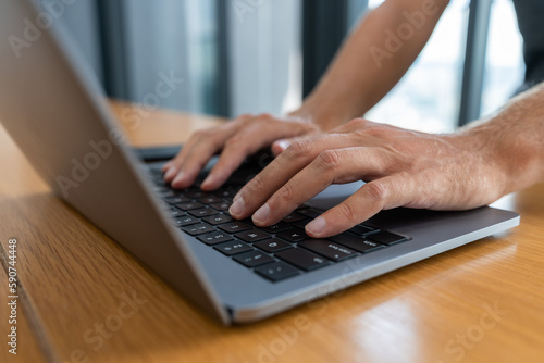 Man hands typing on laptop in office