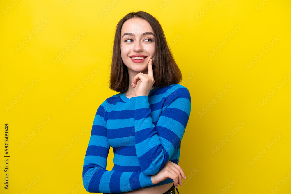 Young Ukrainian woman isolated on yellow background thinking an idea while looking up Young Ukrainian woman isolated on yellow background thinking an idea while looking up