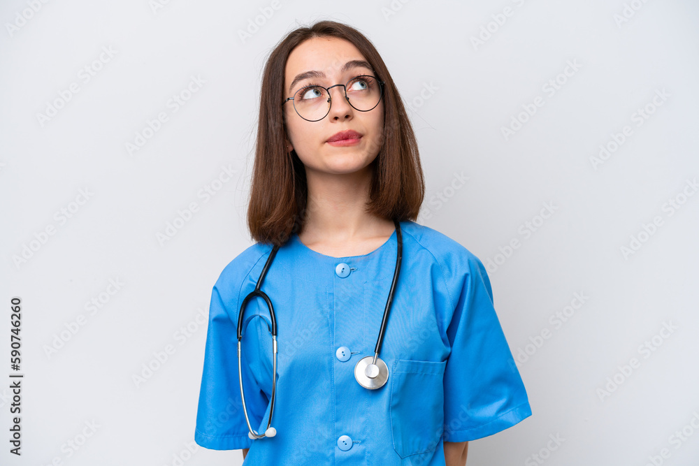 Young nurse Ukrainian woman isolated on white background and looking up Young nurse Ukrainian woman isolated on white background and looking up