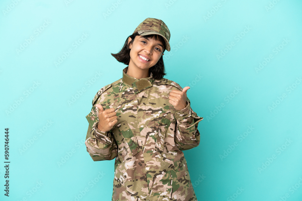 Military mixed race woman isolated on blue background with thumbs up gesture and smiling Military mixed race woman isolated on blue background with thumbs up gesture and smiling