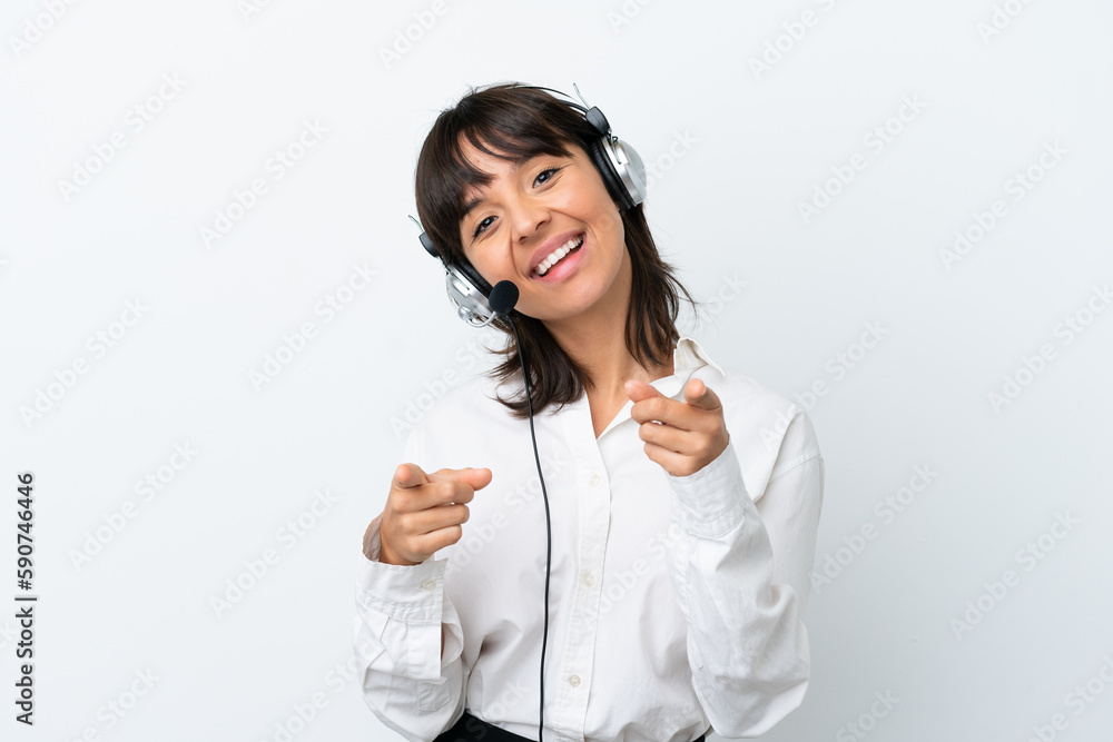 Telemarketer mixed race woman working with a headset isolated on white background points finger at you while smiling Telemarketer mixed race woman working with a headset isolated on white background points finger at you while smiling