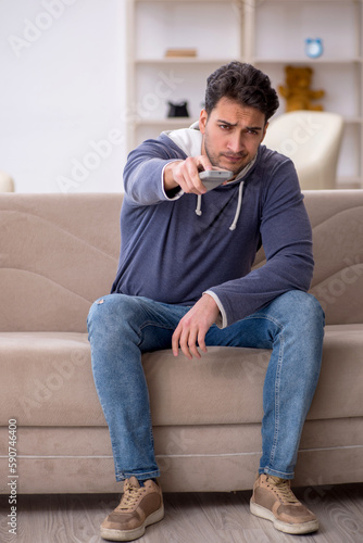 Young man watching tv at home