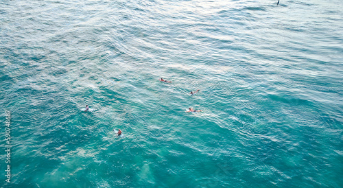 Aerial view of surfers in the ocean waiting for the waves. High quality photo