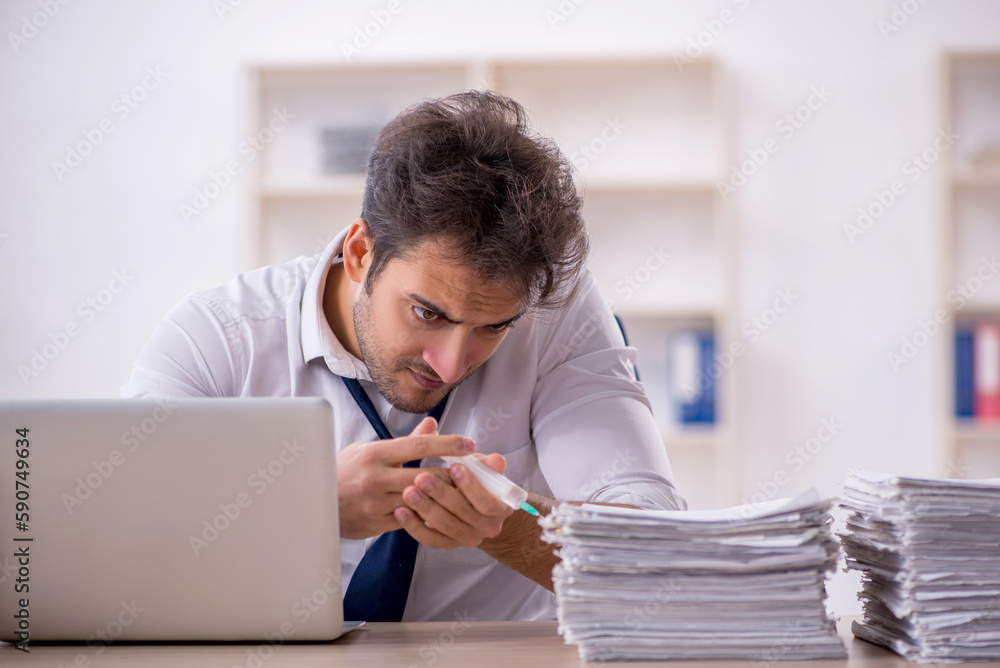 Obraz premium Young male employee and too much work in the office