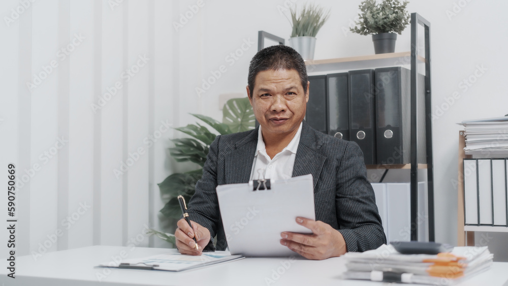 Reading paper charts, Elderly Old Senior Asian male businessman wearing formal suit ,confident professional bookkeeper doing bookkeeping, lawyer, stock market trader or broker. Reading paper charts, Elderly Old Senior Asian male businessman wearing formal suit ,confident professional bookkeeper doing bookkeeping, lawyer, stock market trader or broker.