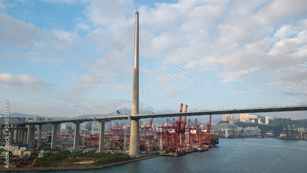Obraz premium Hong Kong - 01.19.2023 View on entrance to container ports area of Hong Kong, part of Stonecutter Bridge, containers terminal and vessel alongside during cargo operations.