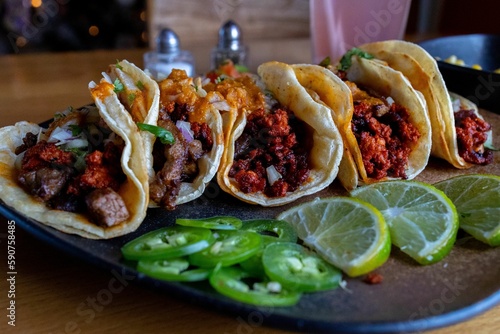 Closeup shot of a steak and Al Pastor tacos on the table photo