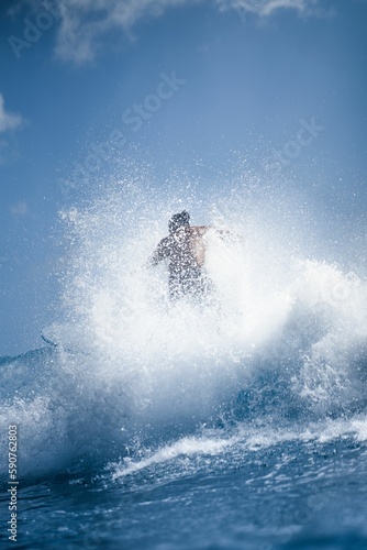 Person surfing in the ocean on a sunny day