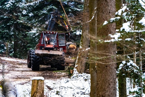 Red industrial machine in the forest in winter.