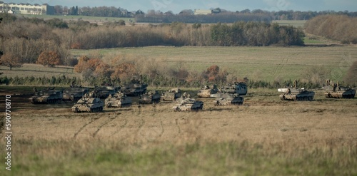 Fototapeta Naklejka Na Ścianę i Meble -  Military tanks moving in a field