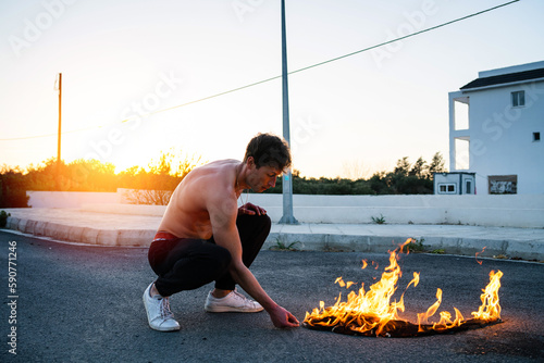 Photography Adult man pyromaniac burning his shirt on the street