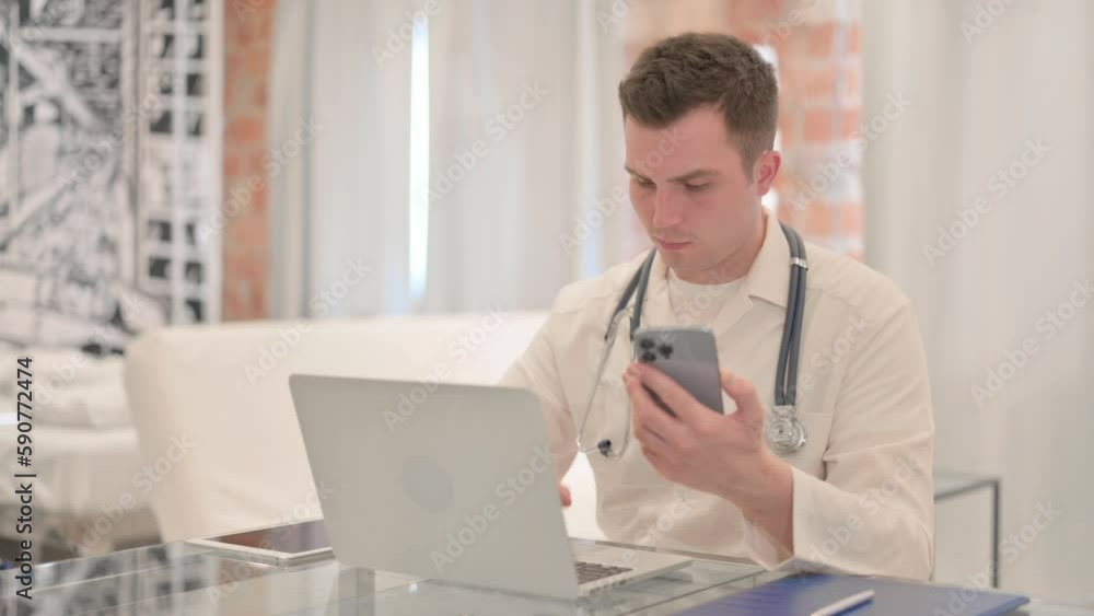 Male Doctor Using Laptop and Smartphone in Clinic Male Doctor Using Laptop and Smartphone in Clinic