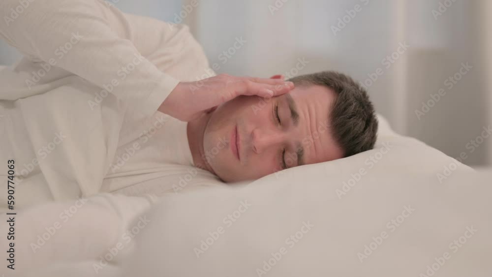 Young Man with Headache Sleeping in Bed on Side Young Man with Headache Sleeping in Bed on Side