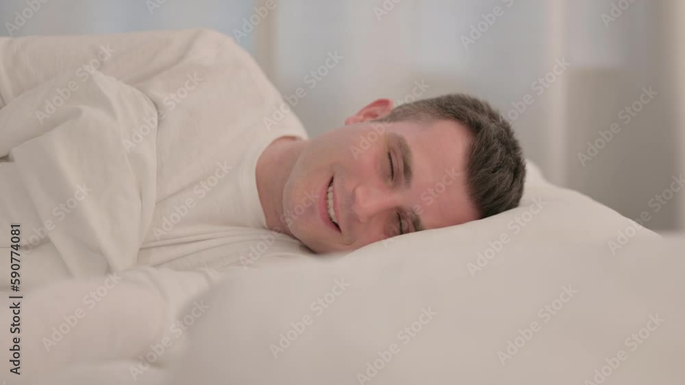 Smiling Young Man Lying in Bed on Side Smiling Young Man Lying in Bed on Side