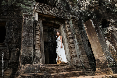 Young woman wearing white robe dress in ancient Khmer ruins, Angkor Wat © blackday