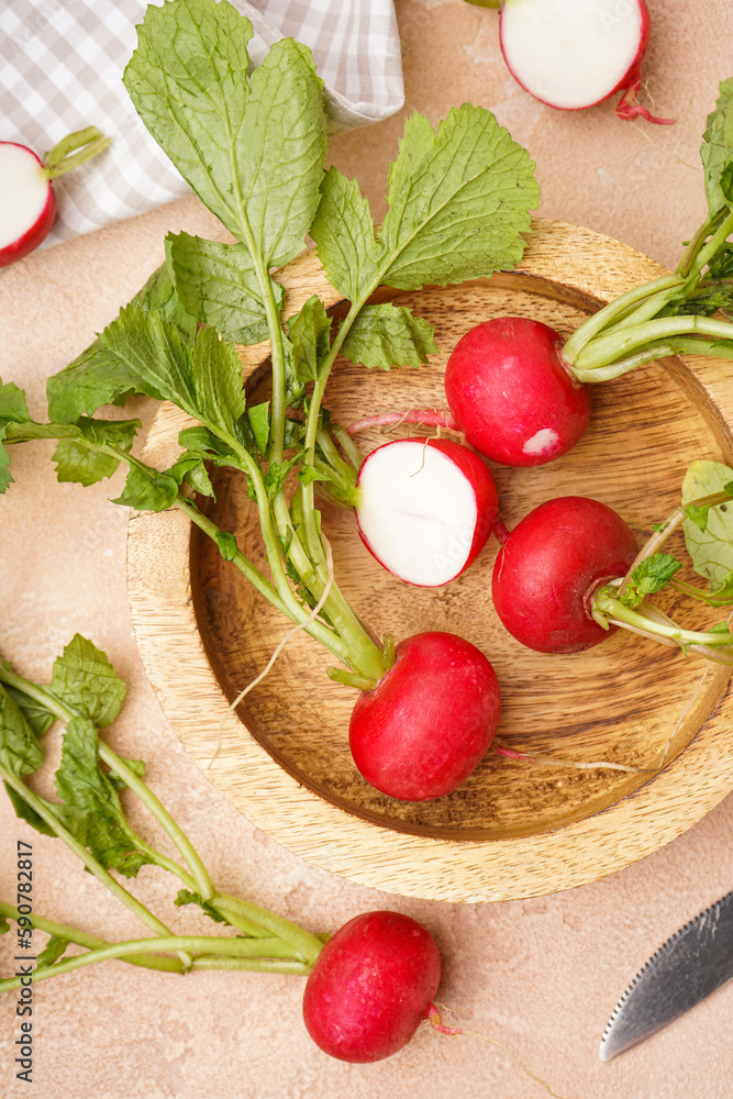 Ripe red radish in a wooden bowl on a beige background, top view. Fresh red radish. Vertically. Ripe red radish in a wooden bowl on a beige background, top view. Fresh red radish. Vertically.
