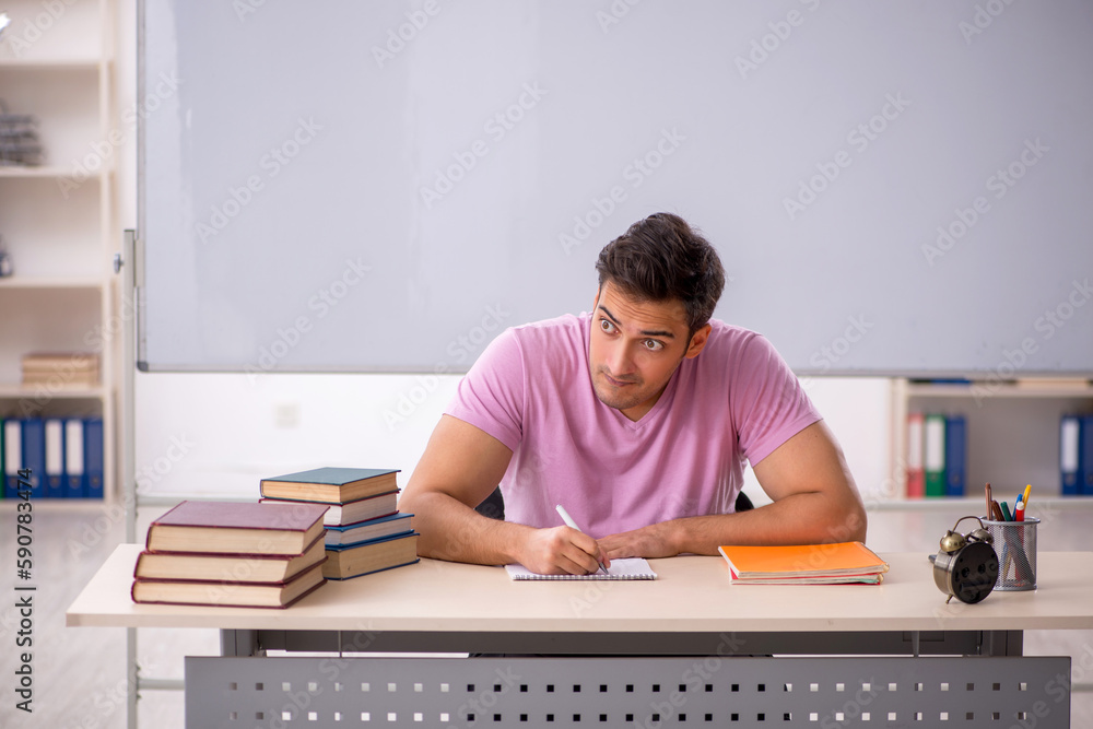 Young male student preparing for exams in time management concep Young male student preparing for exams in time management concep