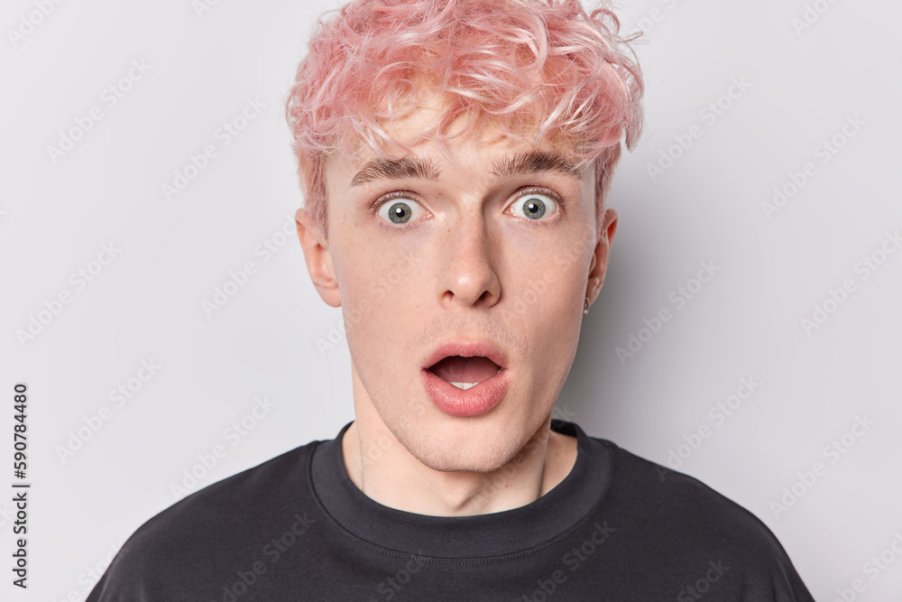 Headshot of scared frightened European man with dyed pink hair gasps from wonder keeps mouth opened dressed in casual black t shirt isolated over white studio background. Omg and reactions concept Headshot of scared frightened European man with dyed pink hair gasps from wonder keeps mouth opened dressed in casual black t shirt isolated over white studio background. Omg and reactions concept