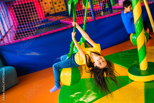 A little girl is having a fun ride on a carousel at the children's play center. Palm tree carousel. The child holds on to the rope and moves around. Children's play center.