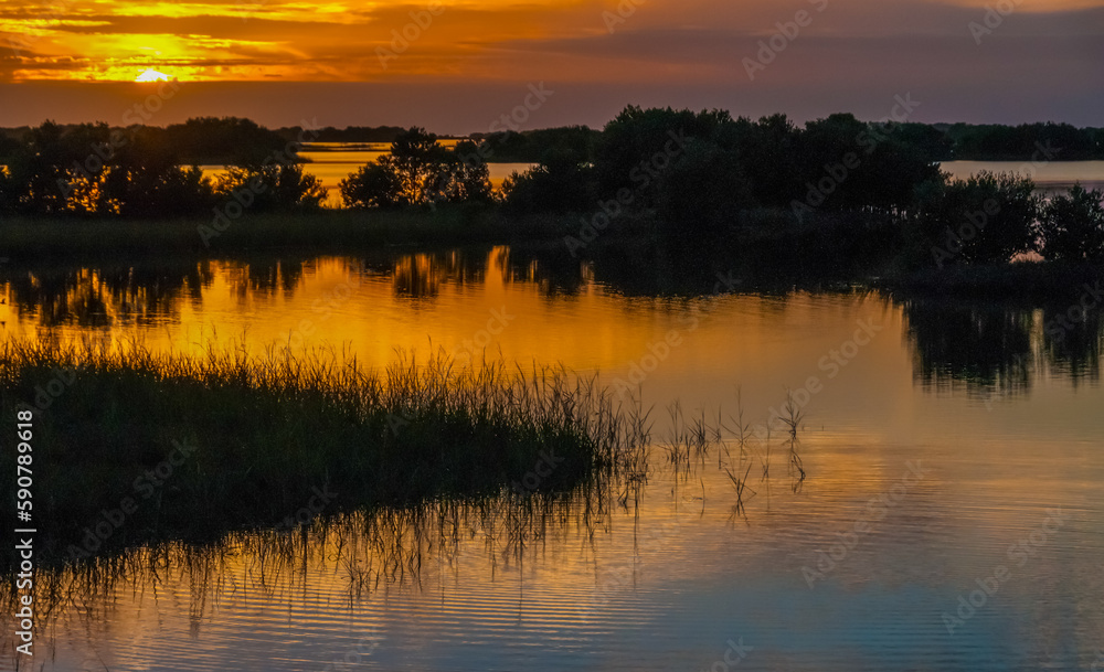 Obraz premium Beautiful sunset over the swamp in Louisiana, the reflection of clouds in the water, USA