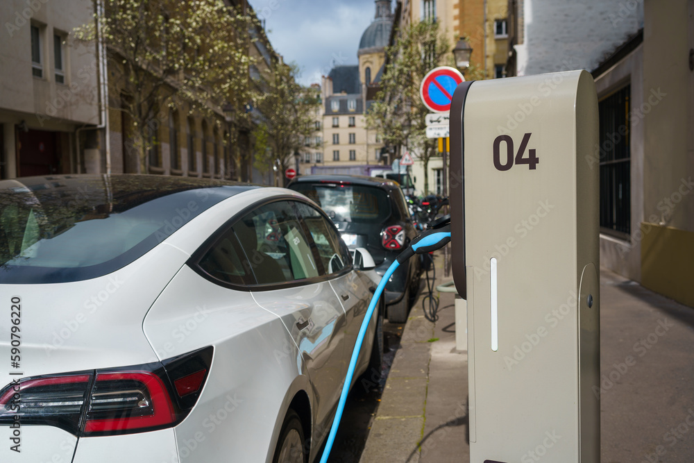 Electric car on charging station in the street of Paris, France.