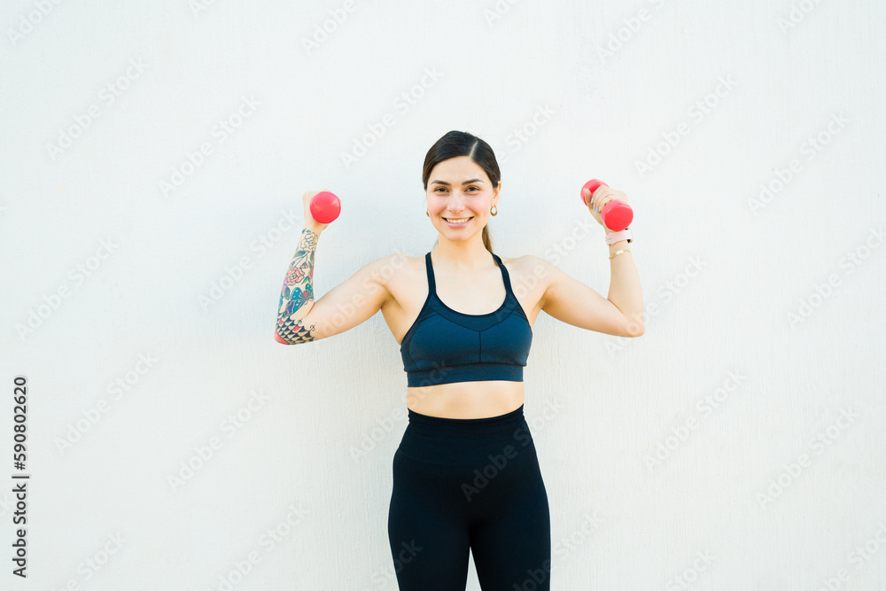 Excited active woman lifting dumbbell weights Excited active woman lifting dumbbell weights