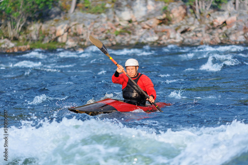 Man in red kayak sails mountain river. Whitewater kayaking, extreme sport rafting © Parilov