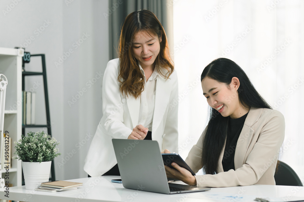 Two professional millennial Asian startup businesspeople are discussing evaluation data in a conference room, focusing on growth and pointing to a financial account chart,graph. Two professional millennial Asian startup businesspeople are discussing evaluation data in a conference room, focusing on growth and pointing to a financial account chart,graph.