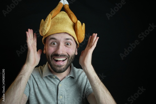 Funny man wearing thanksgiving turkey hat, black background
