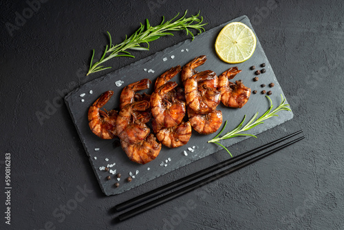 Grilled fried shrimp on a black board dark background top view