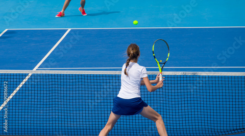 Tennis players play mixed doubles on blue hard courts on a bright sunny day © Павел Мещеряков