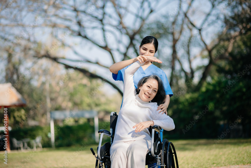 Elderly asian senior woman on wheelchair with careful caregiver and encourage patient, walking in garden. with care from a caregiver and senior health insurance..