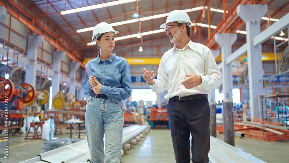 Two professional engineer man and woman manager leader wearing helmet and walking in factory talking and discussing for work