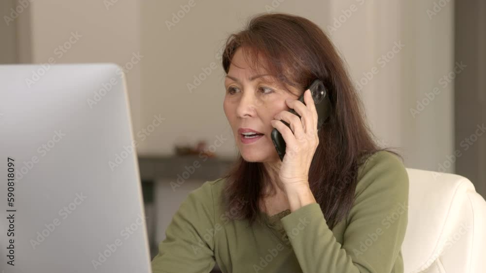 Close up beautiful stylish woman sitting at computer screen talking using mobile cell phone Close up beautiful stylish woman sitting at computer screen talking using mobile cell phone