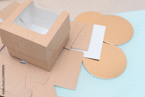 Disposable biodegradable cardboard food containers with window for takeaway delivery close up with selective focus. Craft box for homemade desserts delivery