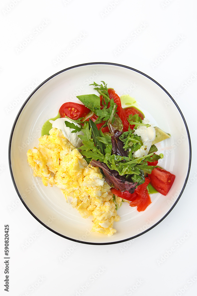 Scrambled eggs on a plate with tomatoes and herbs. Healthy breakfast. Vegetarian menu. The concept of healthy eating.Vertical photo. Copy space. Top view. Scrambled eggs on a plate with tomatoes and herbs. Healthy breakfast. Vegetarian menu. The concept of healthy eating.Vertical photo. Copy space. Top view.