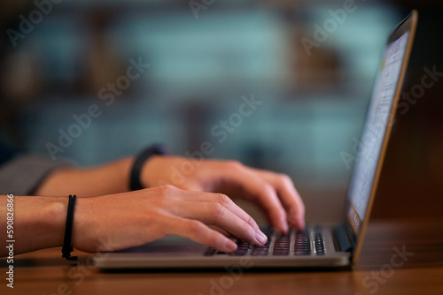 Cropped of man touching laptop computer keyboard, blurred background