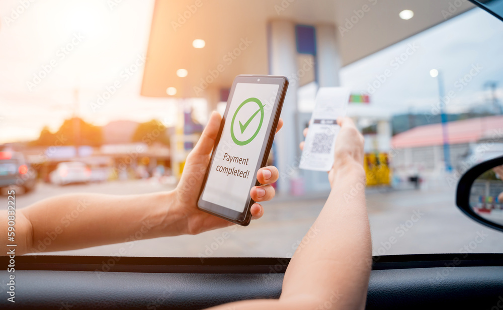 Woman using contactless payment by mobile phone with QR code at car filling station Woman using contactless payment by mobile phone with QR code at car filling station