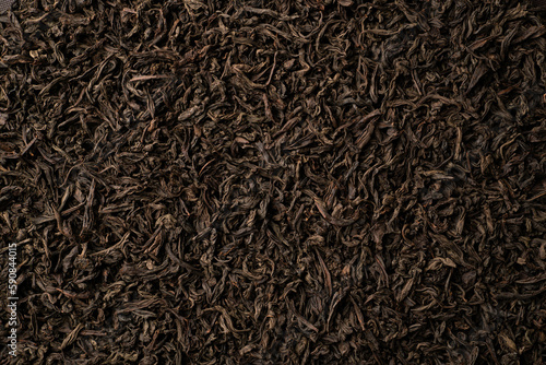 Background of black loose-leaf tea. Close up, top view