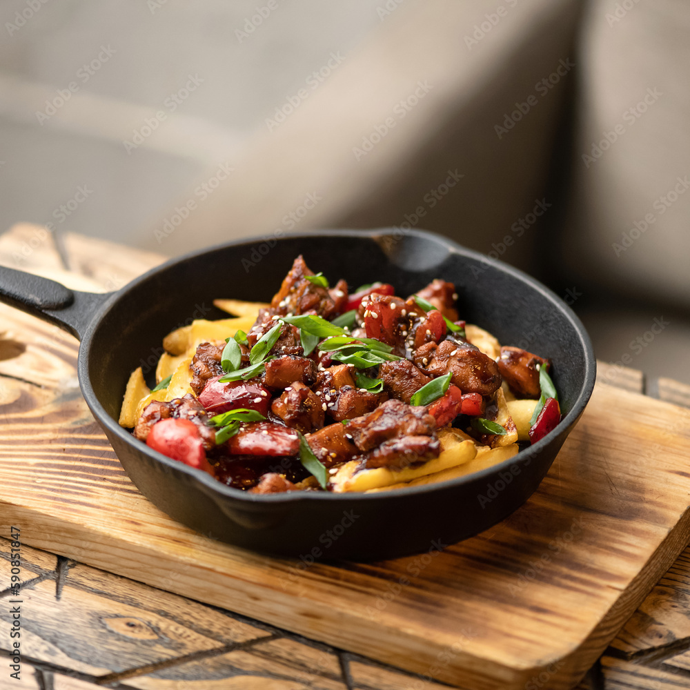 Potatoes with stewed meat in sauce. Meat in sauce. Dish in portion pan on wooden board. Lunch at home. Side view. Copy space. Light gray background. Potatoes with stewed meat in sauce. Meat in sauce. Dish in portion pan on wooden board. Lunch at home. Side view. Copy space. Light gray background.