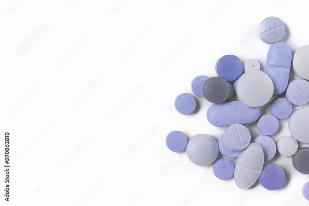 Assorted pills on a neutral background with light blue colors. Assorted pills on a neutral background with light blue colors.