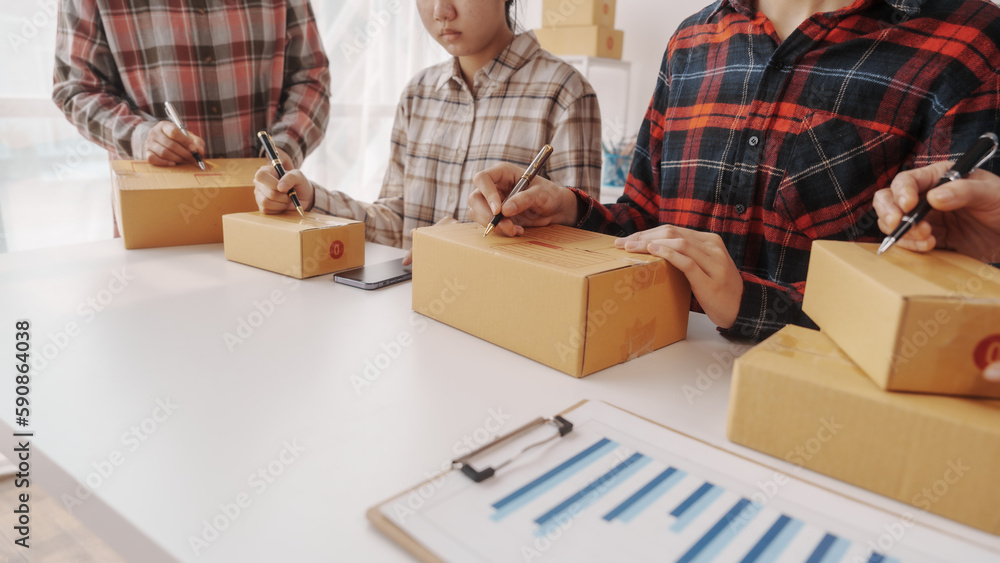 Team of smes warehouse checking email and writing on parcel cardboard box, Small business entrepreneur, SME, freelance online sellers, influencer and the team behind the work. Team of smes warehouse checking email and writing on parcel cardboard box, Small business entrepreneur, SME, freelance online sellers, influencer and the team behind the work.