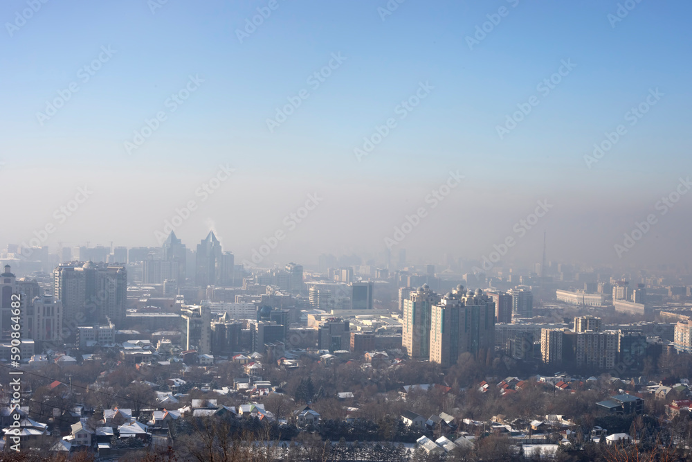 View of Almaty city from Kok Tobe mountain on winter afternoon. Foggy Almaty city view at winter in Kazakhstan, Central Asia