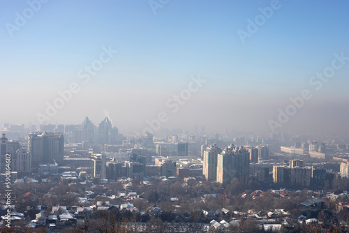 View of Almaty city from Kok Tobe mountain on winter afternoon. Foggy Almaty city view at winter in Kazakhstan, Central Asia © Mystery