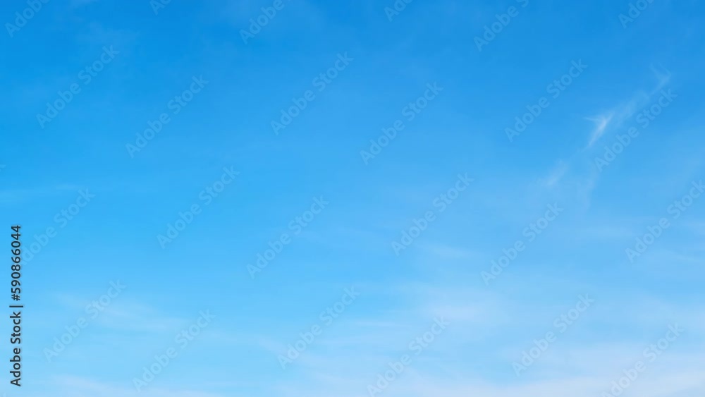 White cirrus and stratus clouds in a blue daytime sky, timelapse